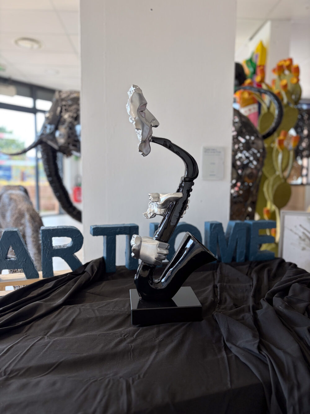 Sculpture saxophone noir brillant avec visage et mains argentées 64 cm ArtHome